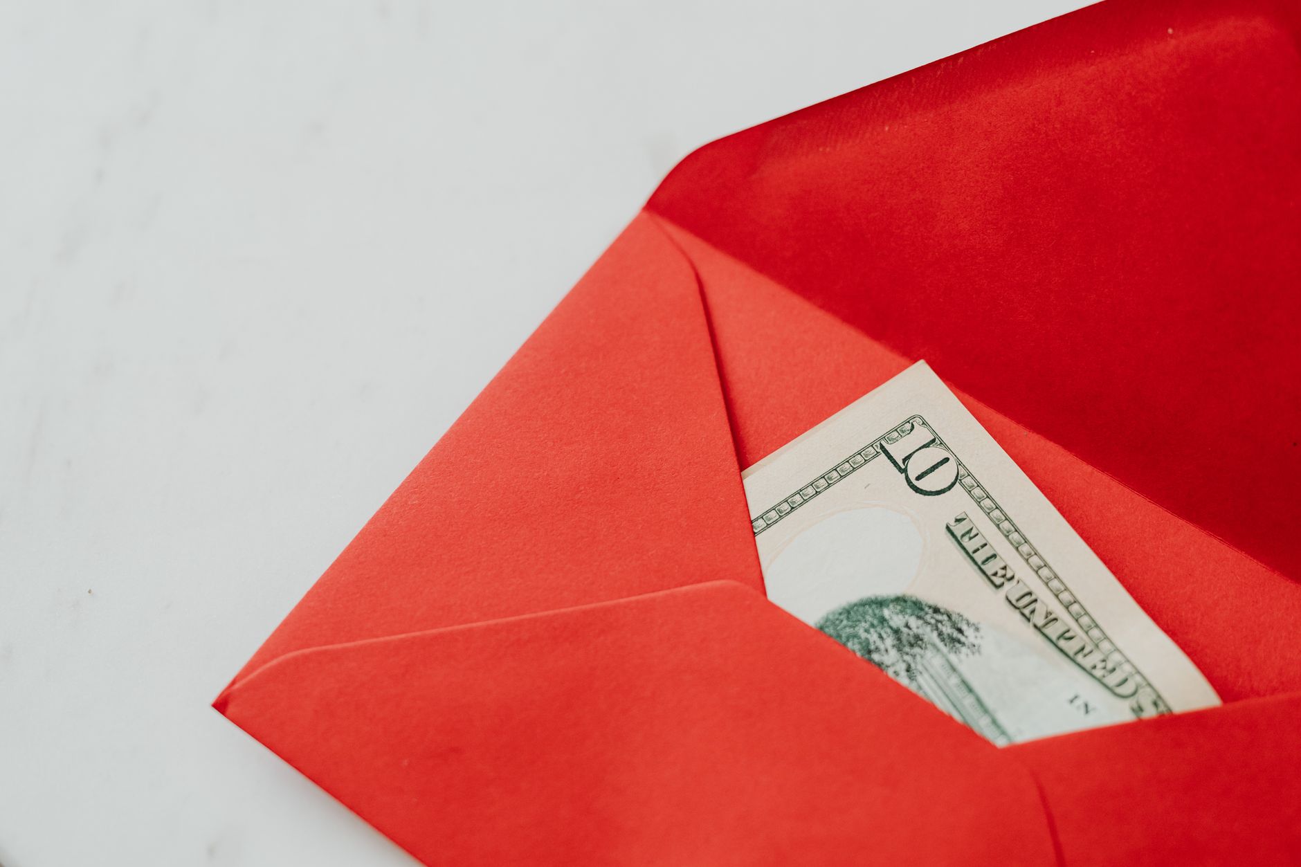 Close-up shot of cash in a red envelope, symbolizing gifting or New Year traditions.
