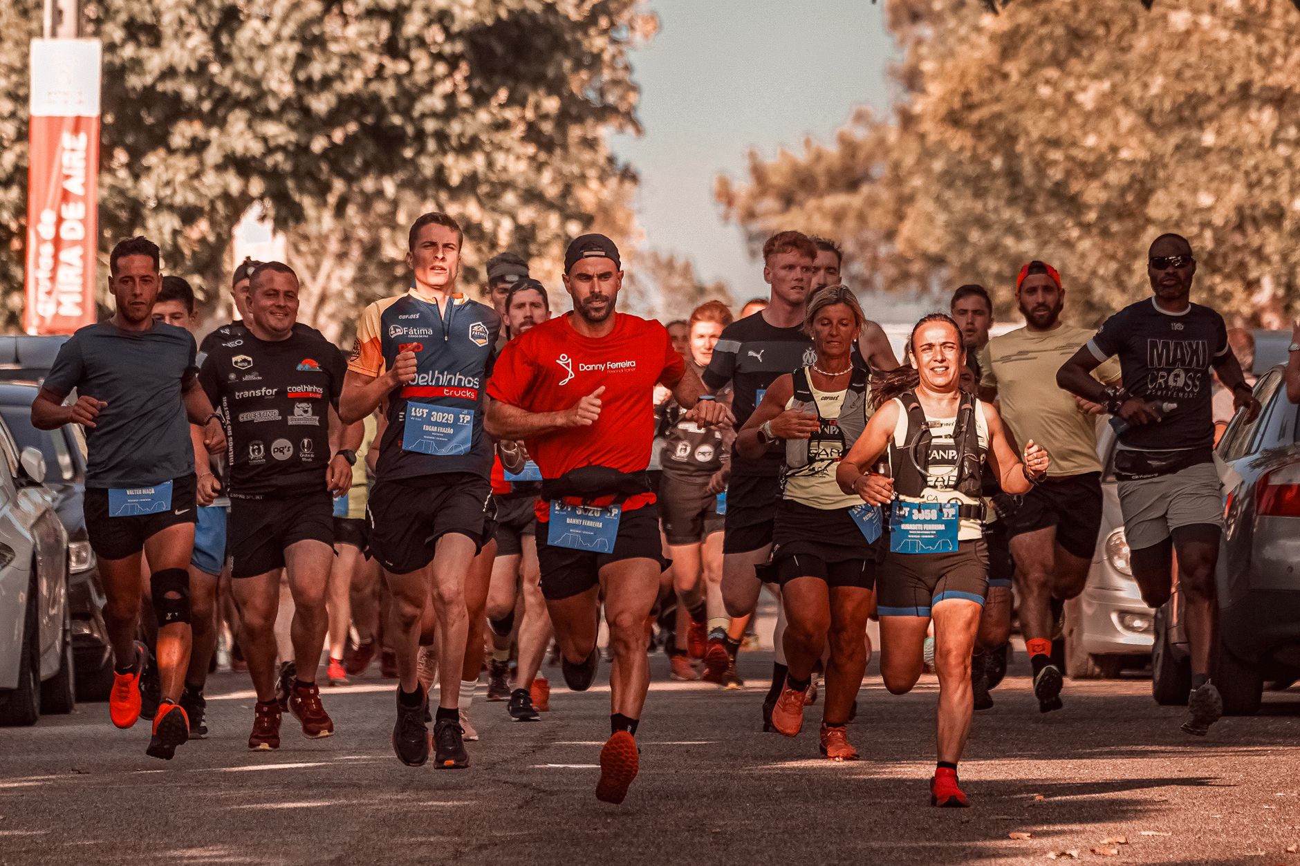 A group of adults participating in a running race on a city street in daylight, showcasing sportsmanship.
