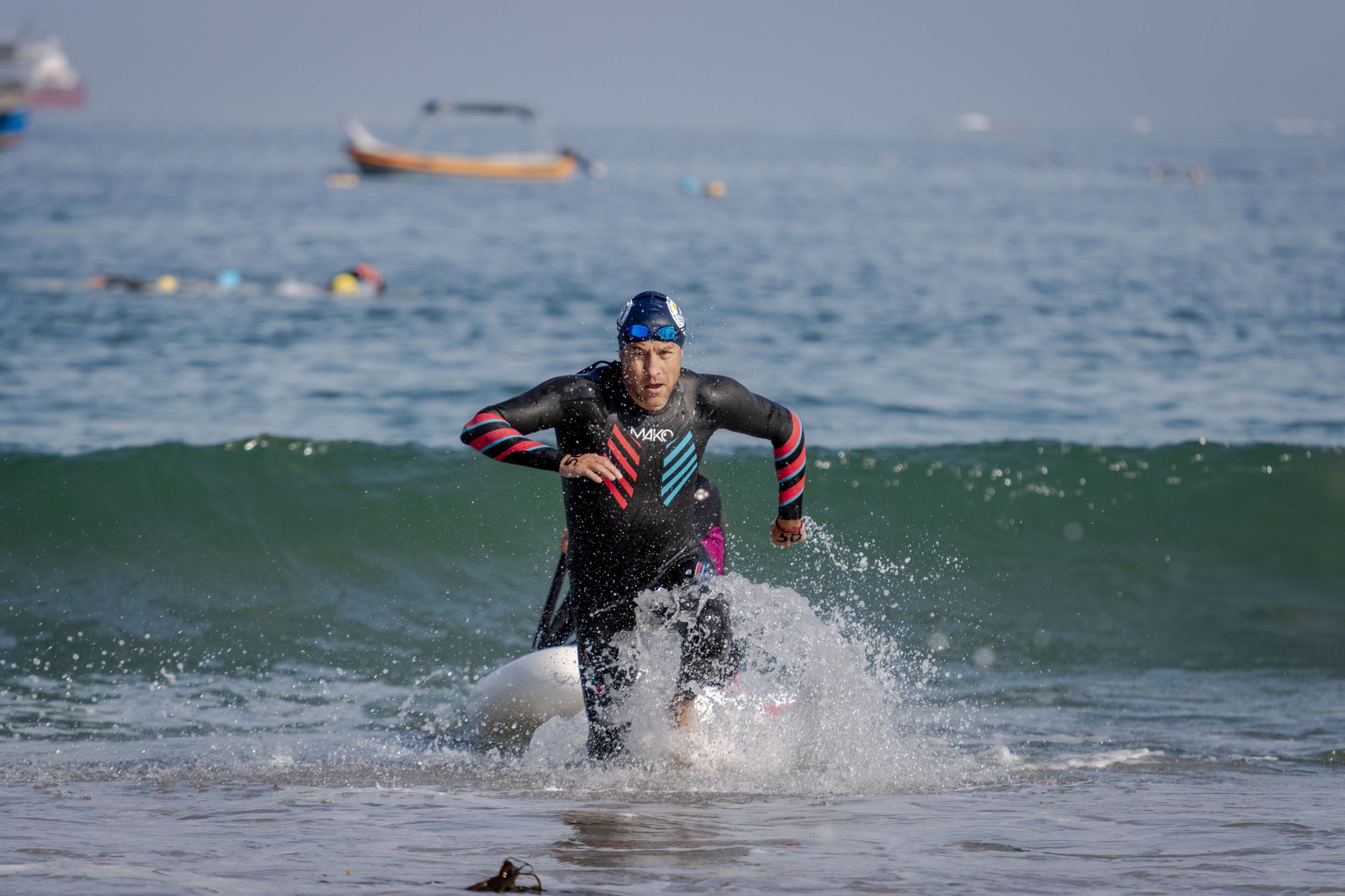 Dynamic shot of an athlete emerging from the sea during a triathlon, showcasing endurance and determination.
