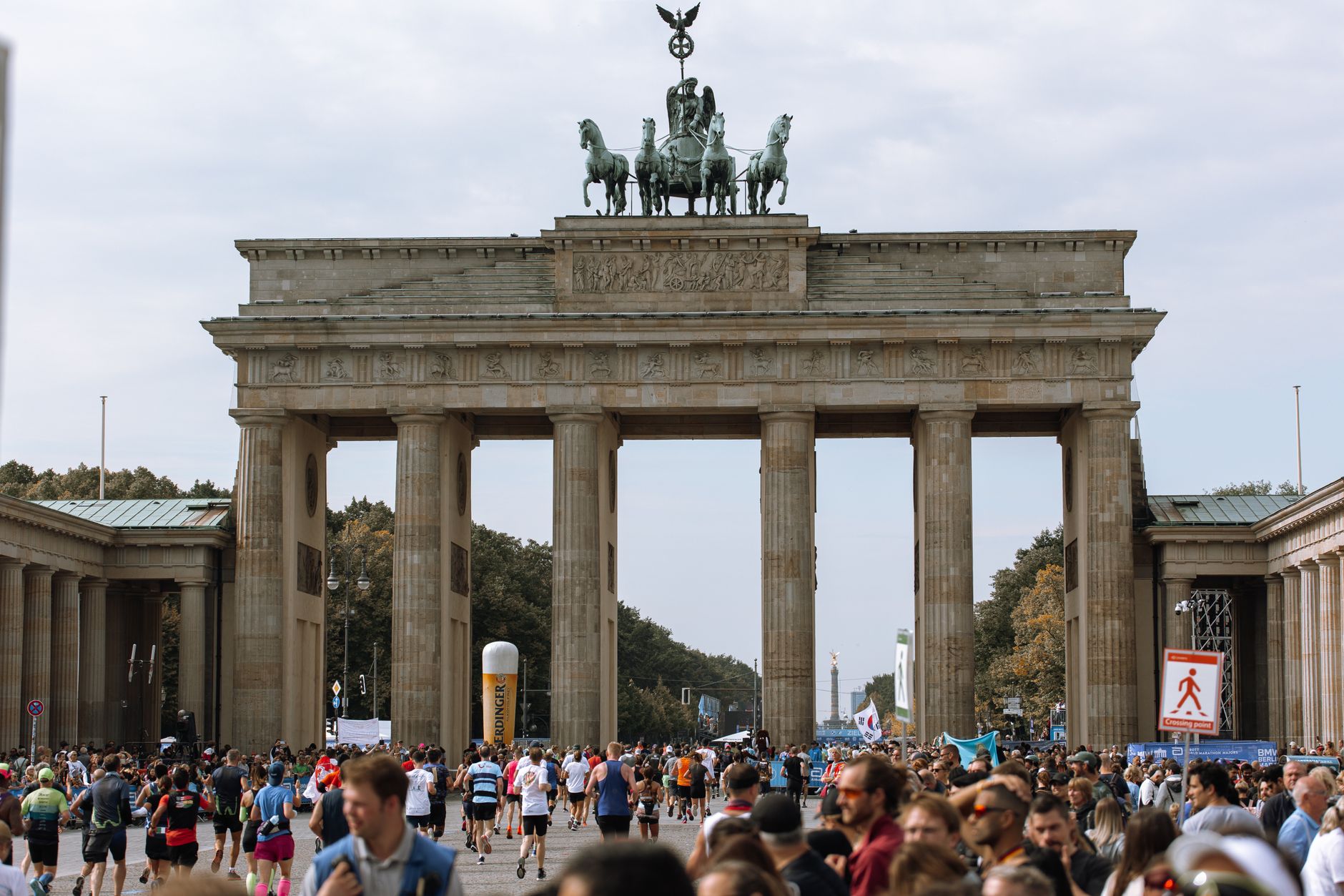 Brandenburg Gate with marathon participants and crowds in Berlin, Germany.