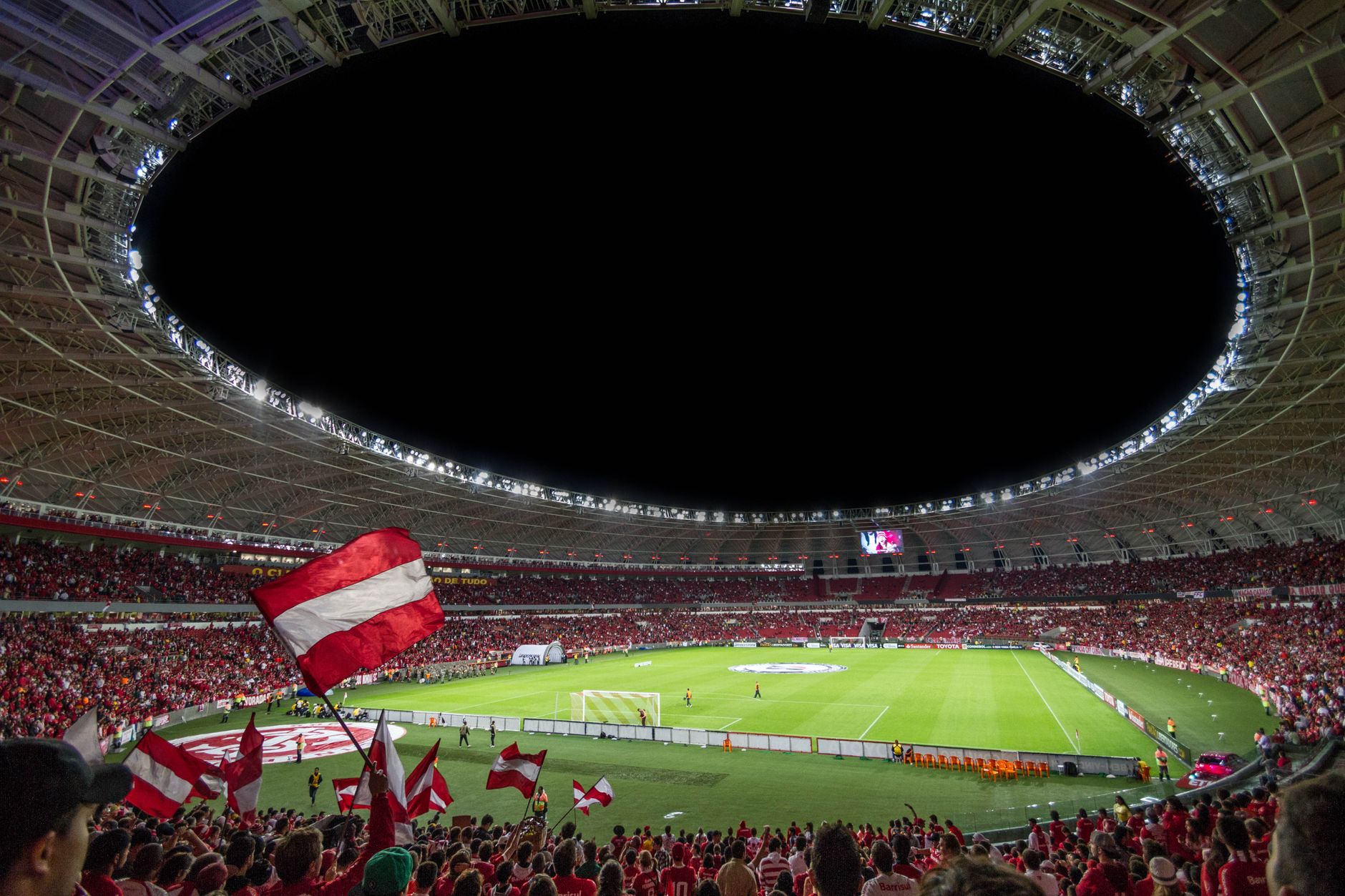 Exciting soccer match with enthusiastic fans in a packed stadium under bright lights.