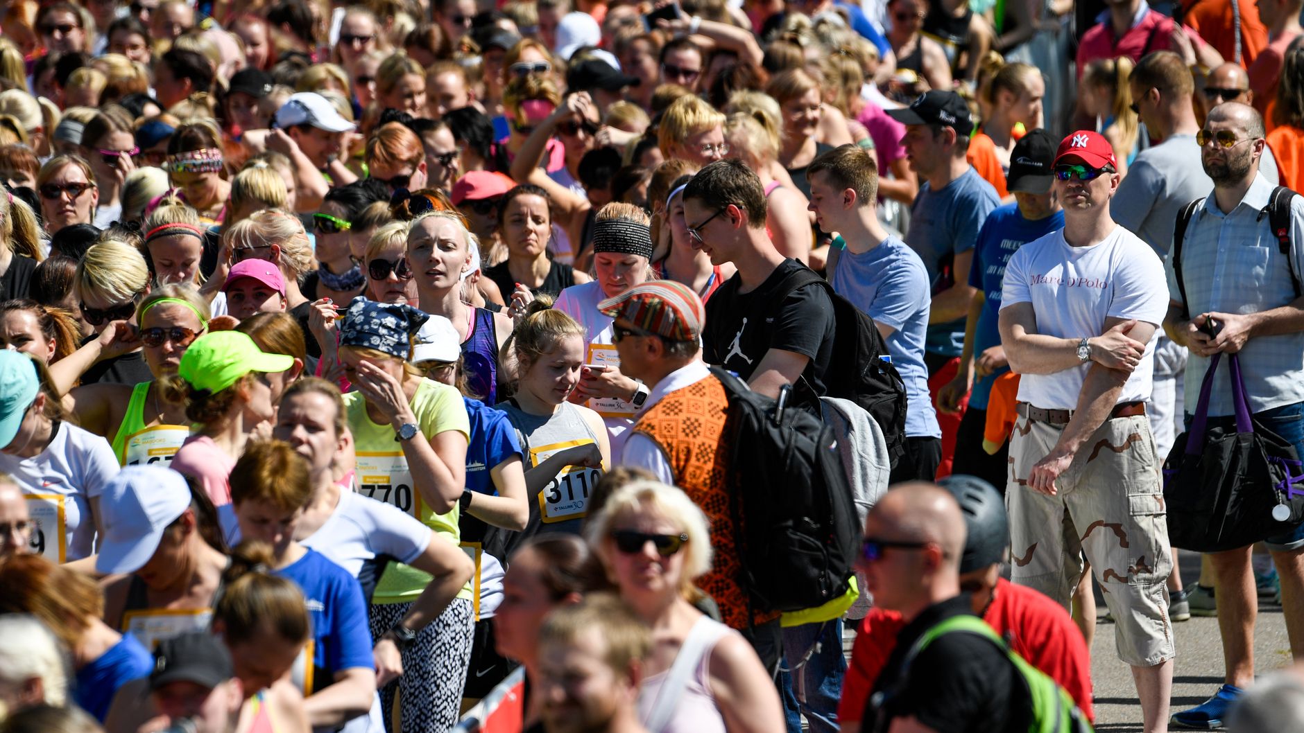 Crowd of runners at the start line of a marathon in Tallinn, Estonia during summer.