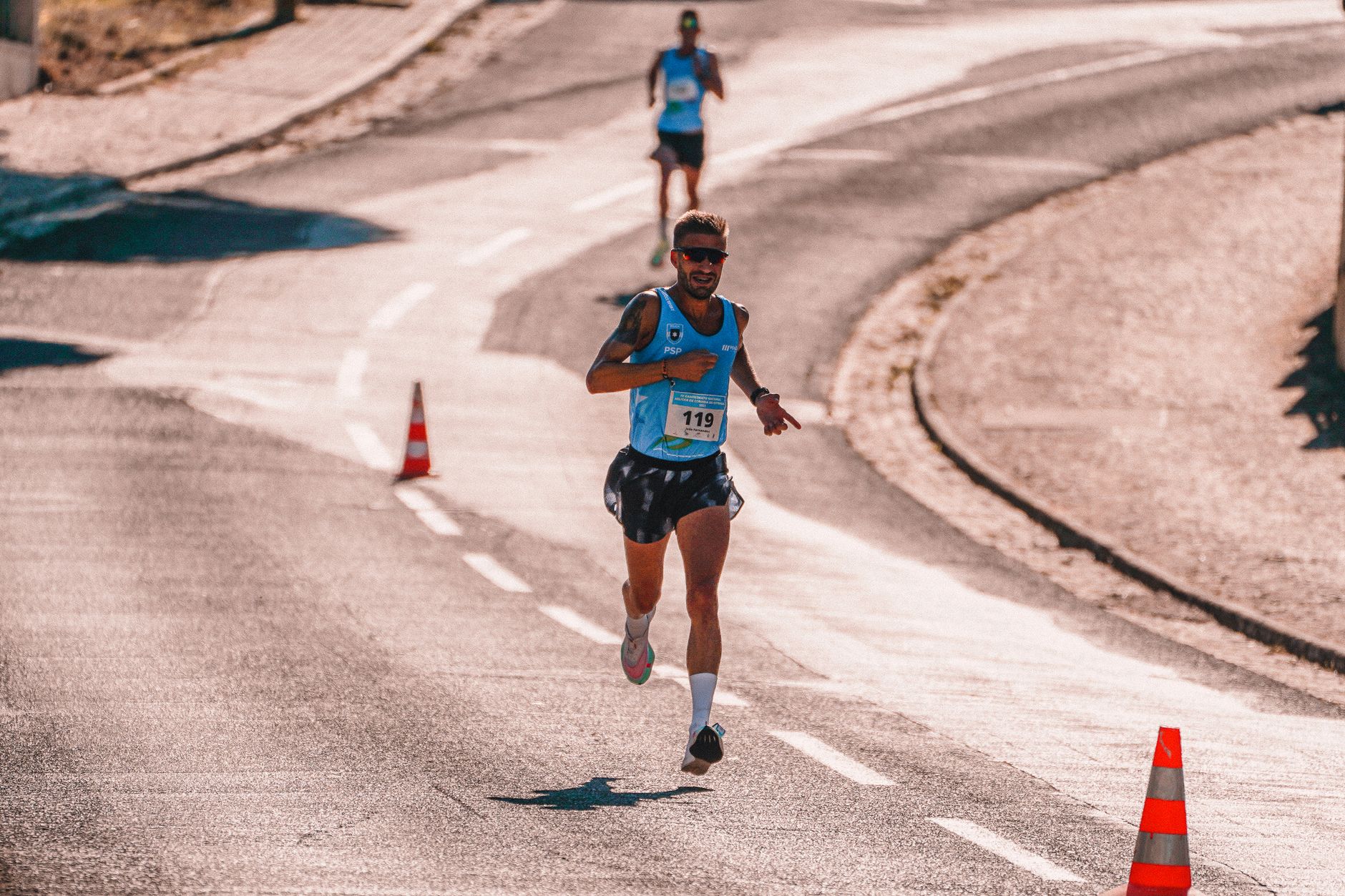 Focused male athlete competing in an outdoor marathon race on a sunny day.