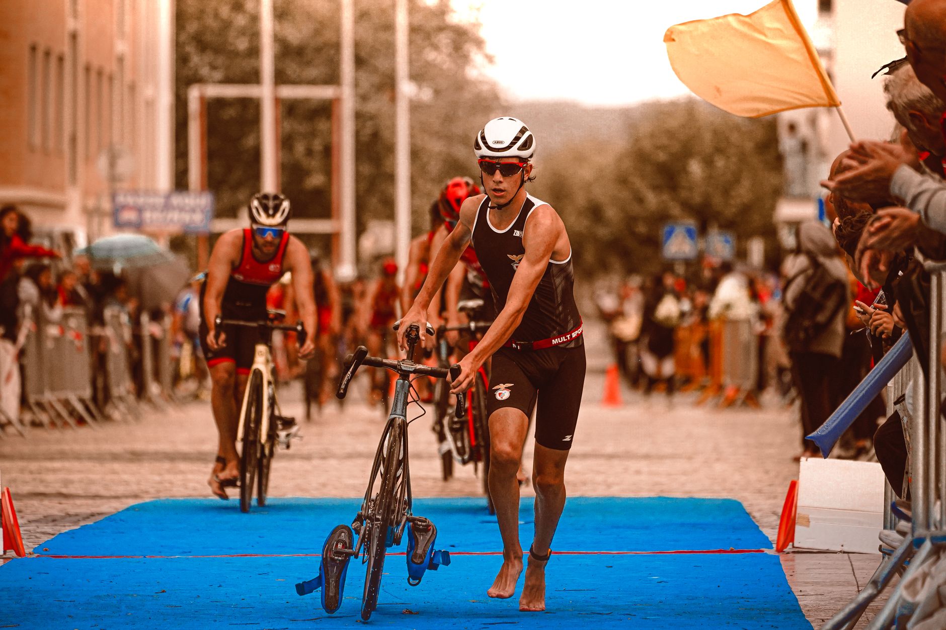 Triathletes in action at the transition area during a competitive event, showcasing athleticism and determination.