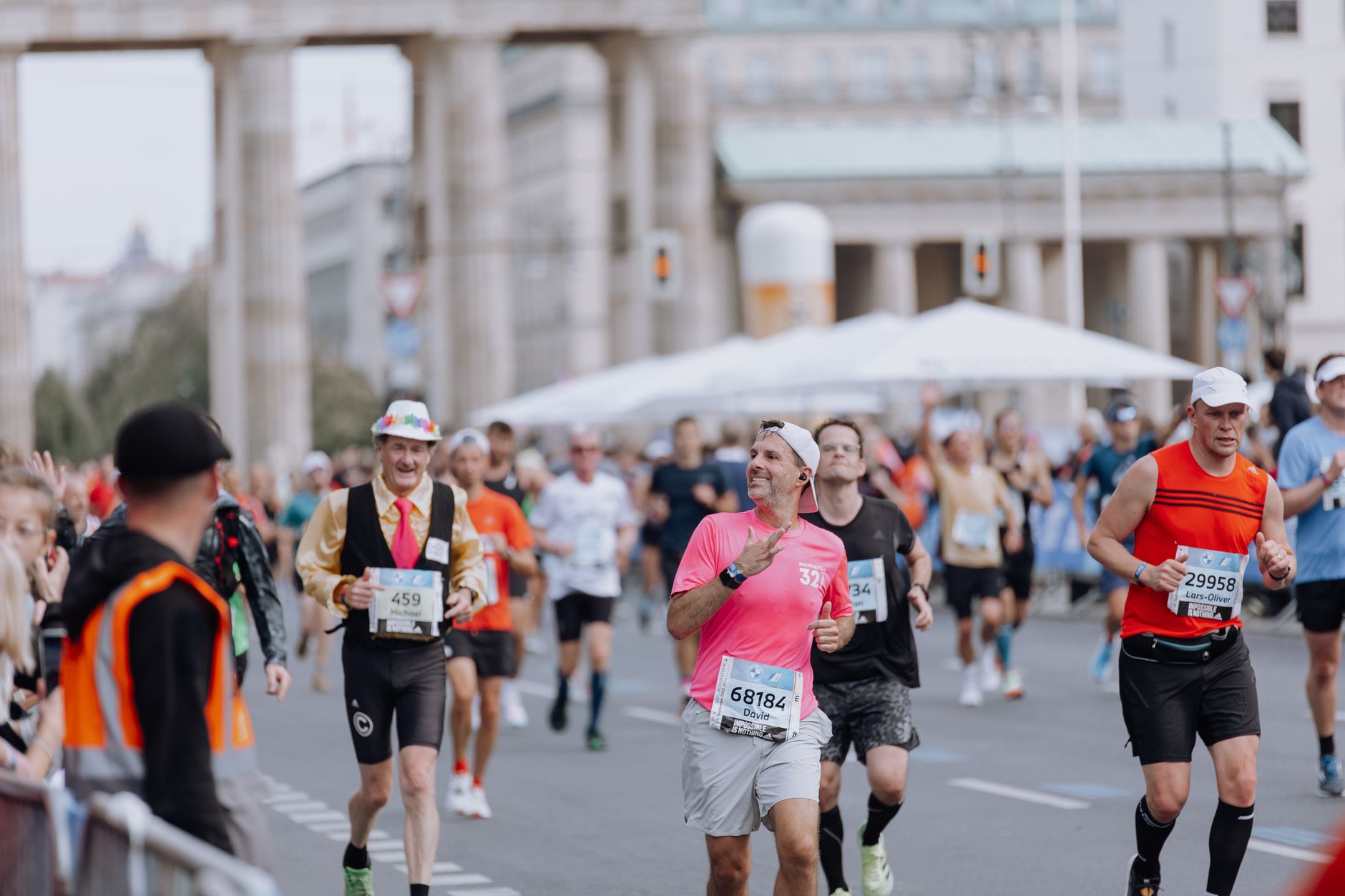 Diverse group of runners competing in marathon near iconic monument, capturing a lively and energetic atmosphere.
