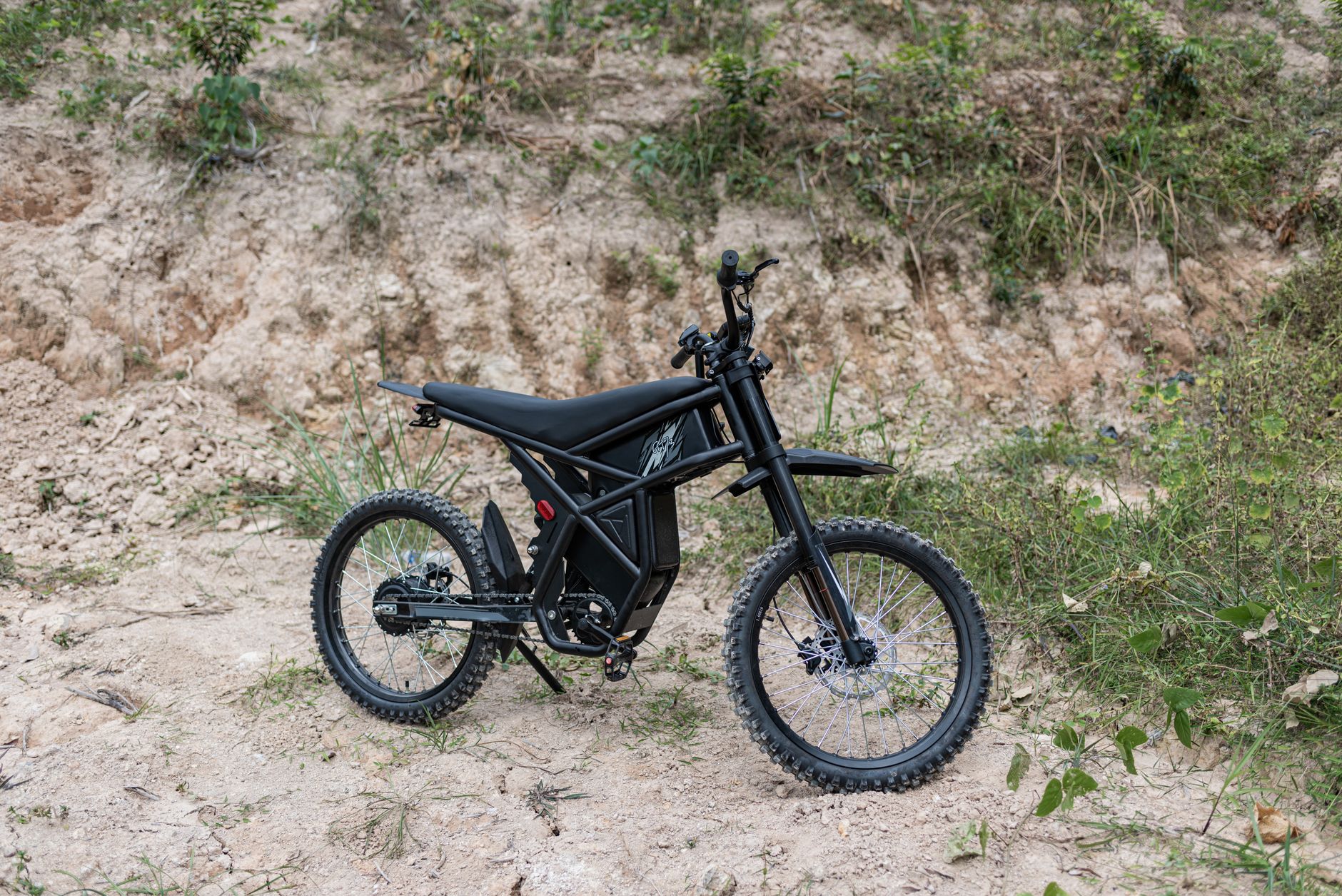 Modern black electric bike on rocky outdoor terrain, perfect for rugged adventures.