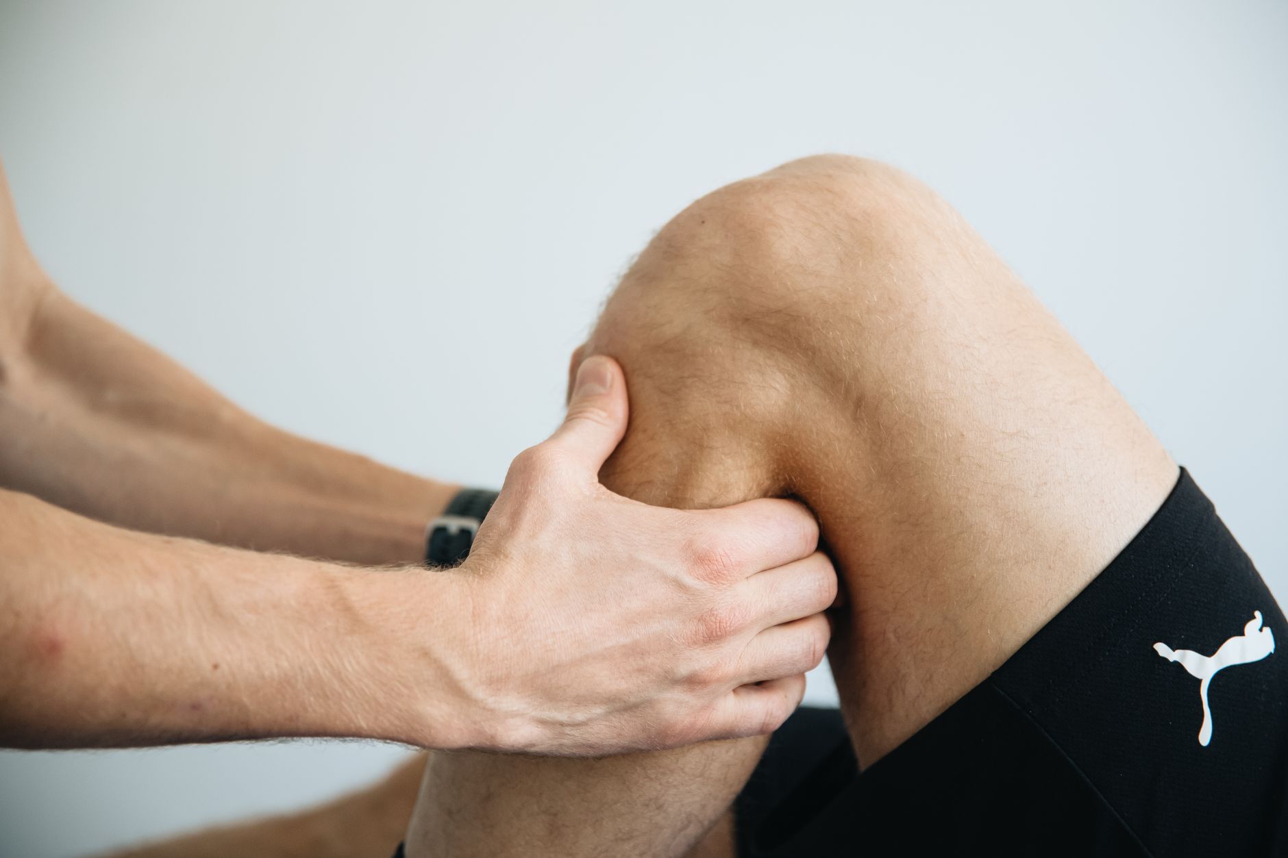 Detailed image of a physiotherapy session focusing on knee massage treatment.