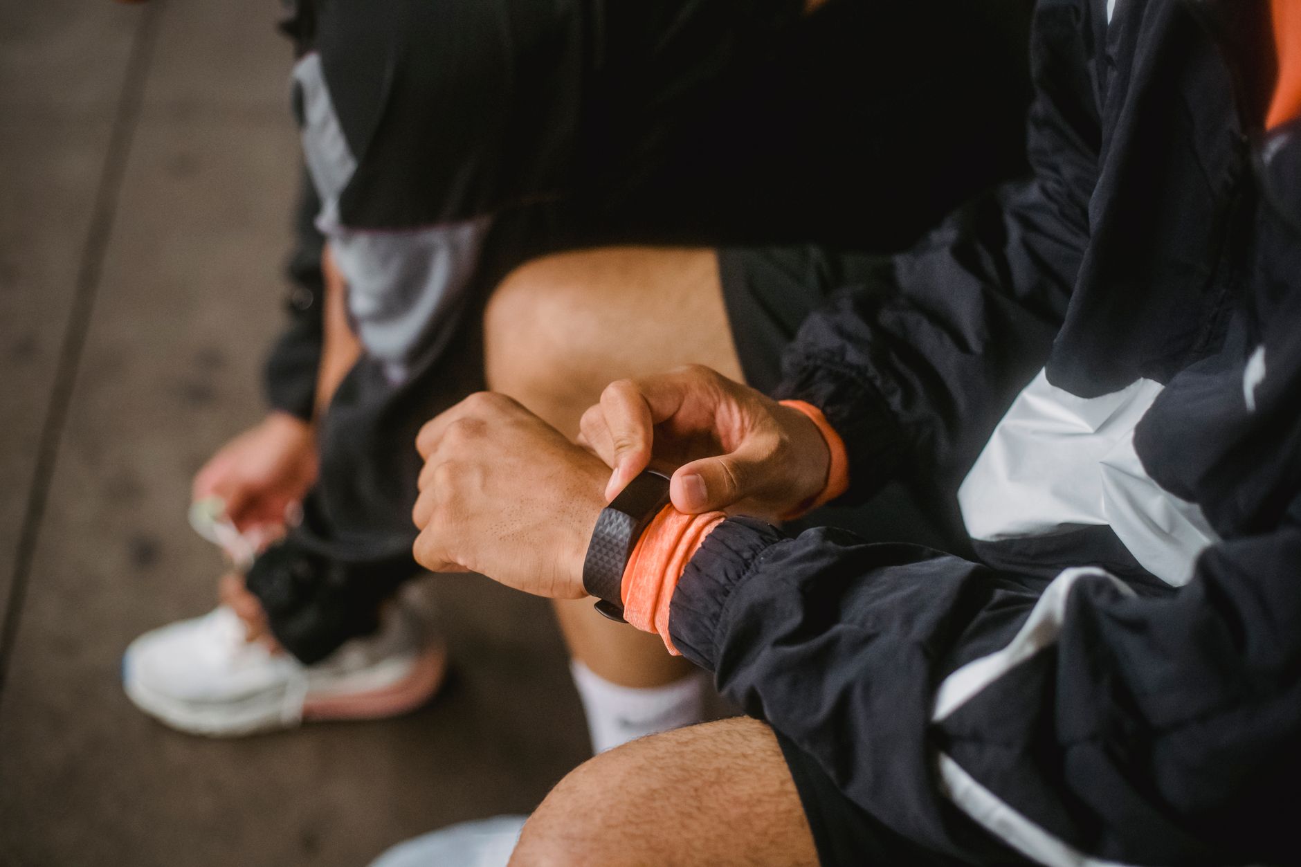 Close-up of a man in athletic wear adjusting a smartwatch, showcasing fitness and technology integration.