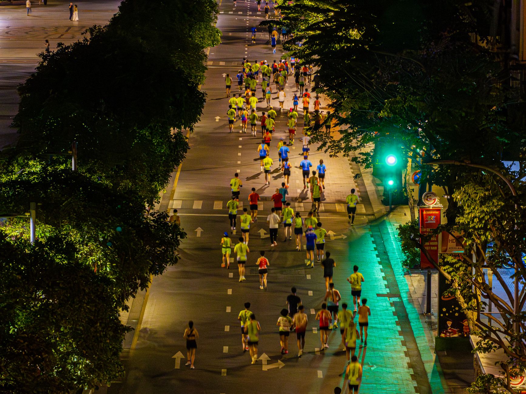 Crowd of marathon runners at night from above, showcasing urban city life.