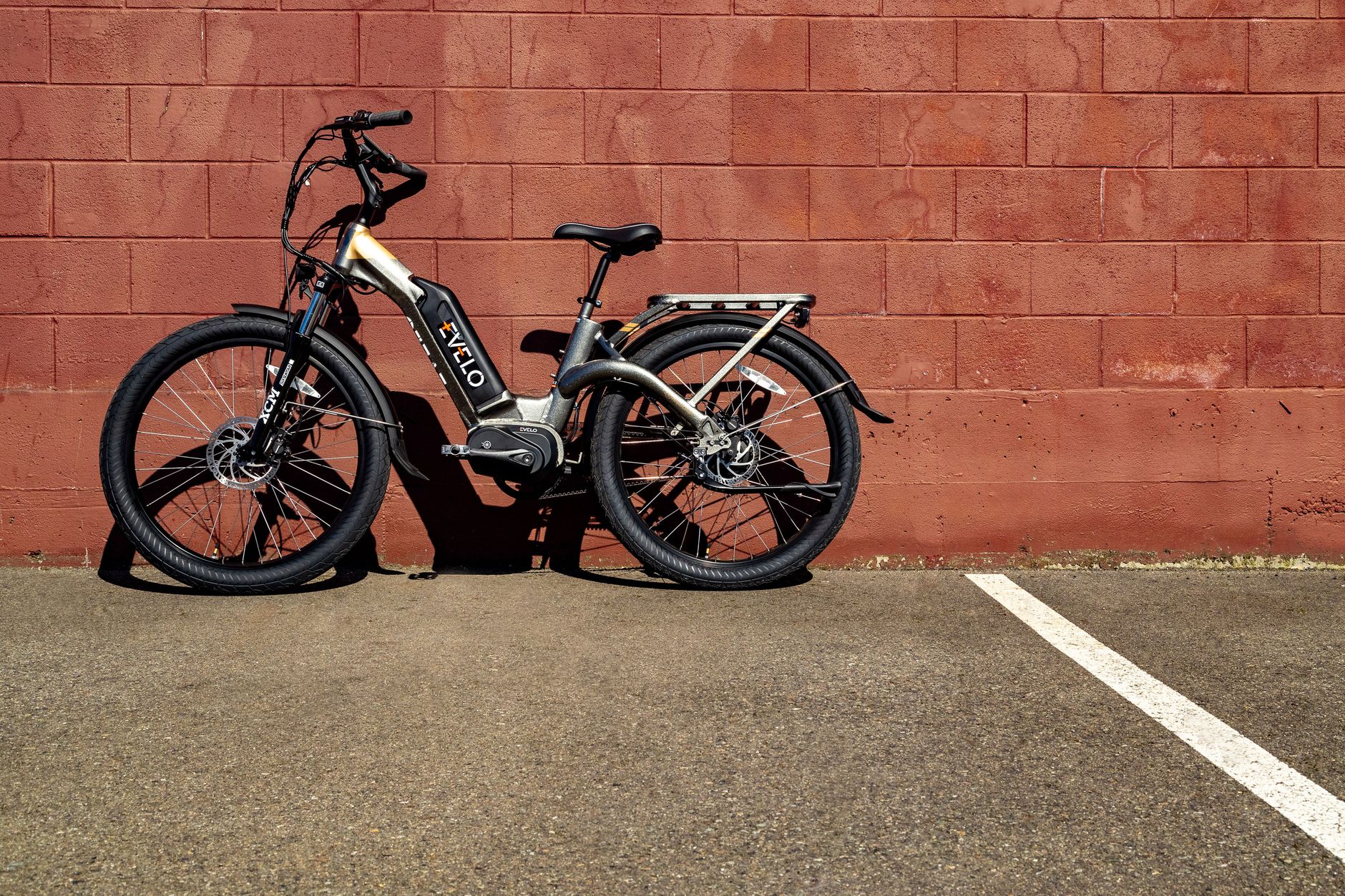 Electric bike resting against a red brick wall on a sunny day in Seattle.