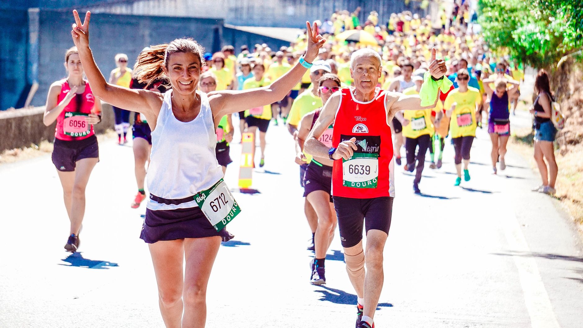A group of diverse runners participating in a lively marathon event under the sun.