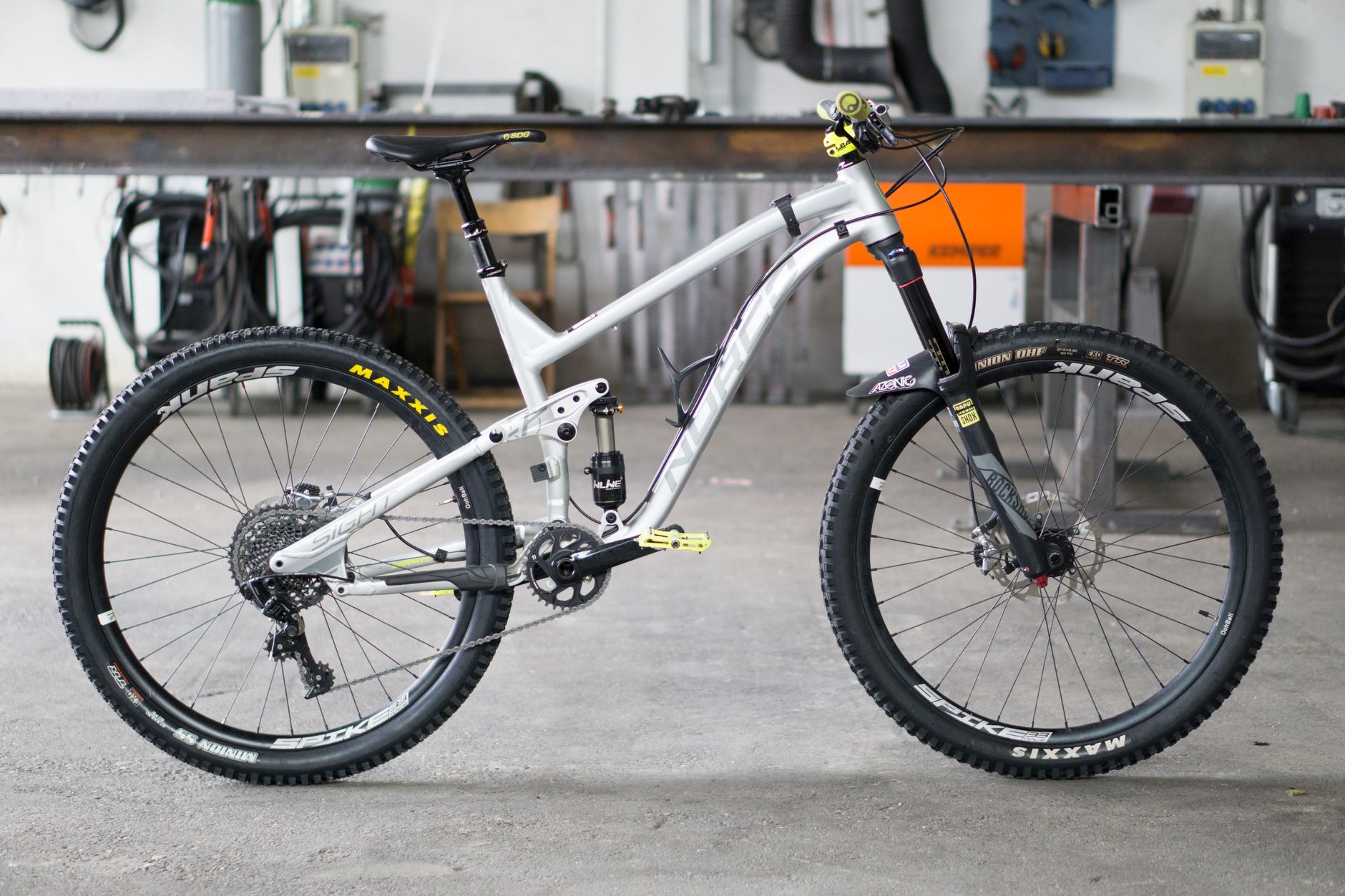 Detailed shot of a mountain bike in a workshop, highlighting design and components.