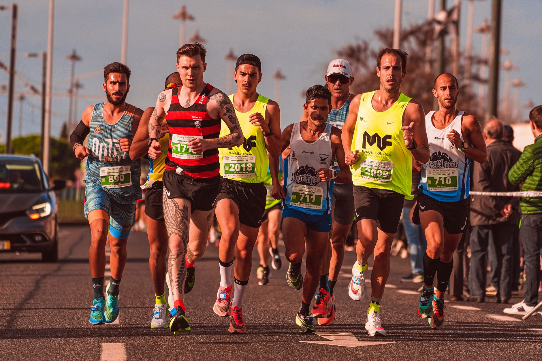 A diverse group of male runners competing in an outdoor marathon race, showcasing athletic endurance and team spirit.