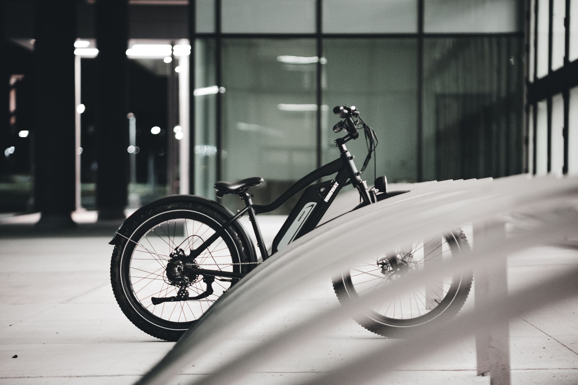 Stylish black electric bike parked in a sleek urban environment at night.