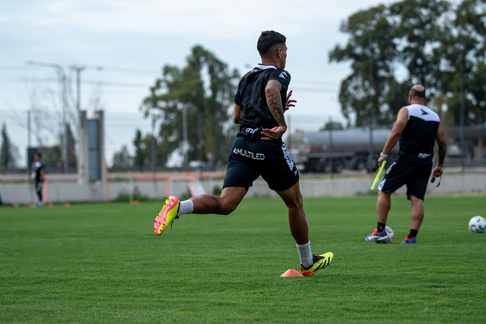 Athletes engage in a dynamic outdoor soccer training session, showcasing agility and teamwork.